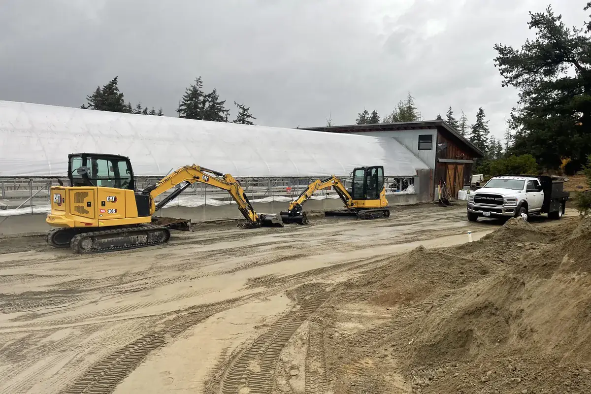 Excavators shaping a site